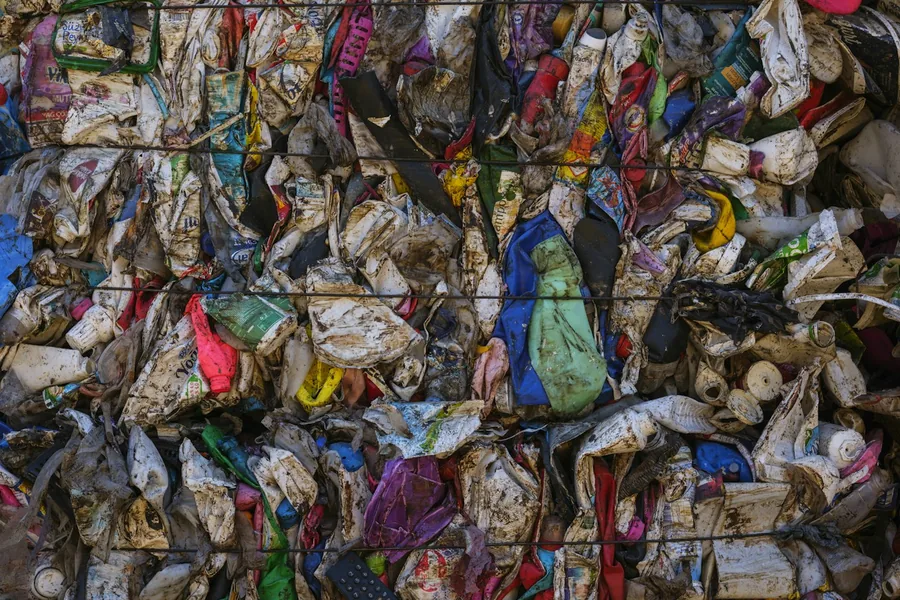 Compressed bales of sorted recycling stacked at a processing facility
